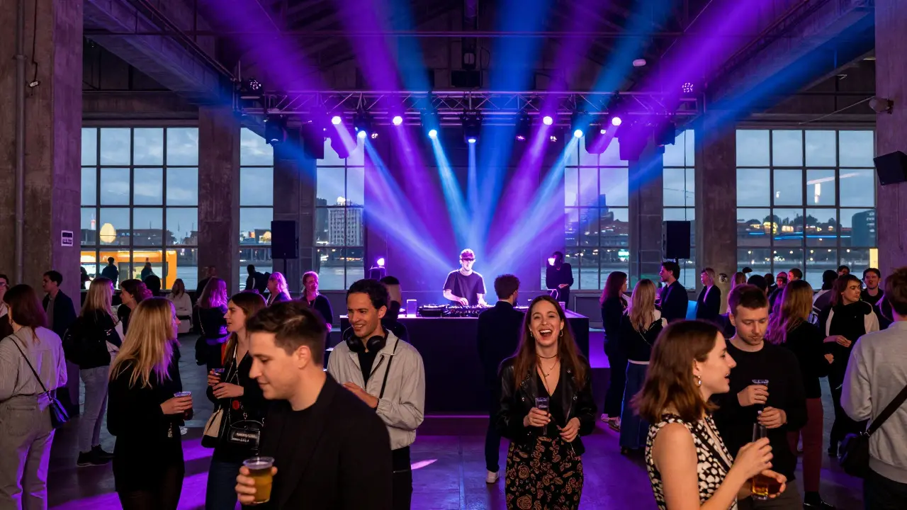 Crowd socializing and dancing under colorful lights in the industrial hall of Tate Modern
